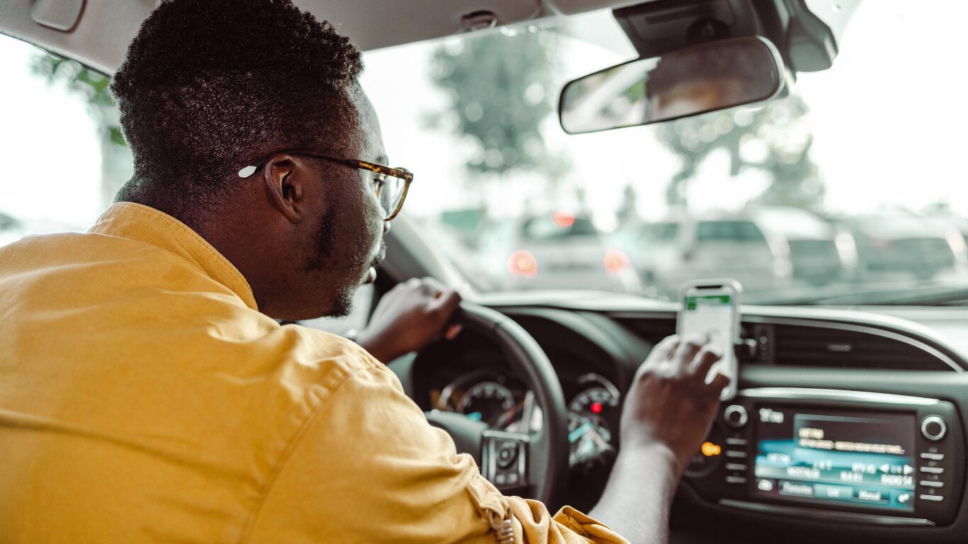 Motorista De Aplicativo Da Zona Sul De São Paulo Sorrindo Dentro Do Carro, Representando O Trabalhador Autônomo Que Pode Comprovar Renda E Financiar Um Apê Pelo Minha Casa Minha Vida Com A Iapartamentos Conquista.